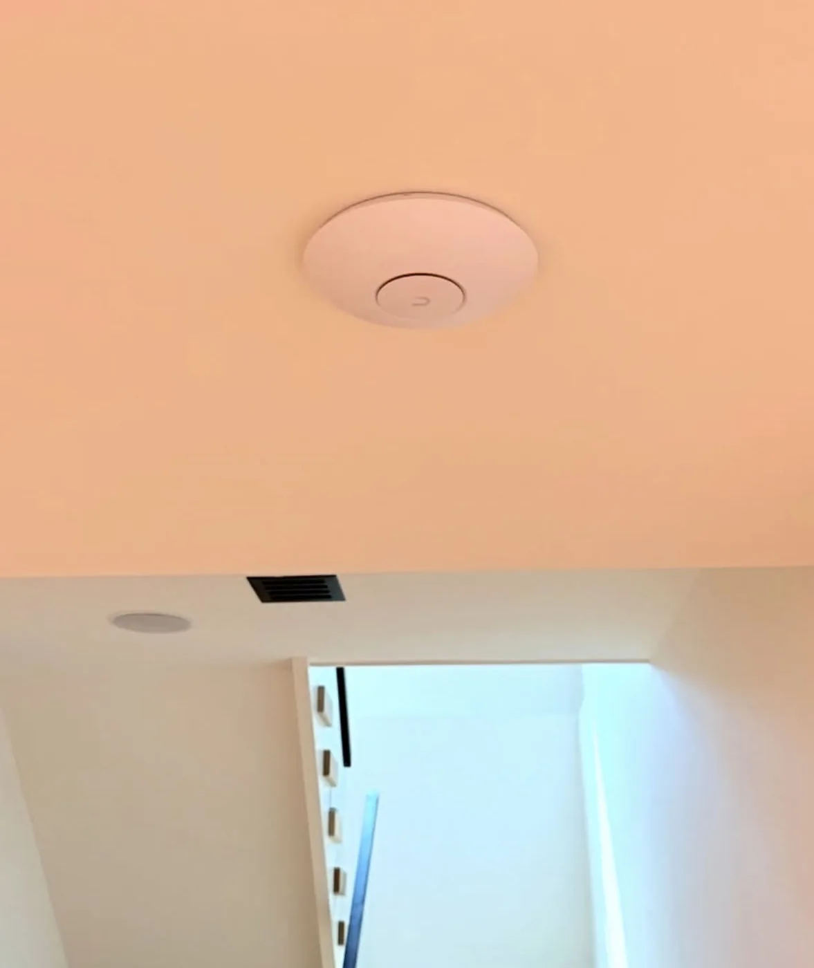 Wifi-punt in het plafond naast een trapgat naar de bovenverdieping